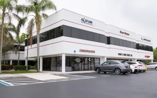 Chiropractic Palm Beach Gardens FL Clinic HP An exterior photo of a white office building with black windows, where Siegal Chiropractic is located